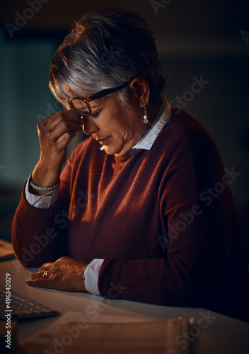 It might be time to call it a night. Shot of a mature businesswoman looking stressed out while working late in an office.