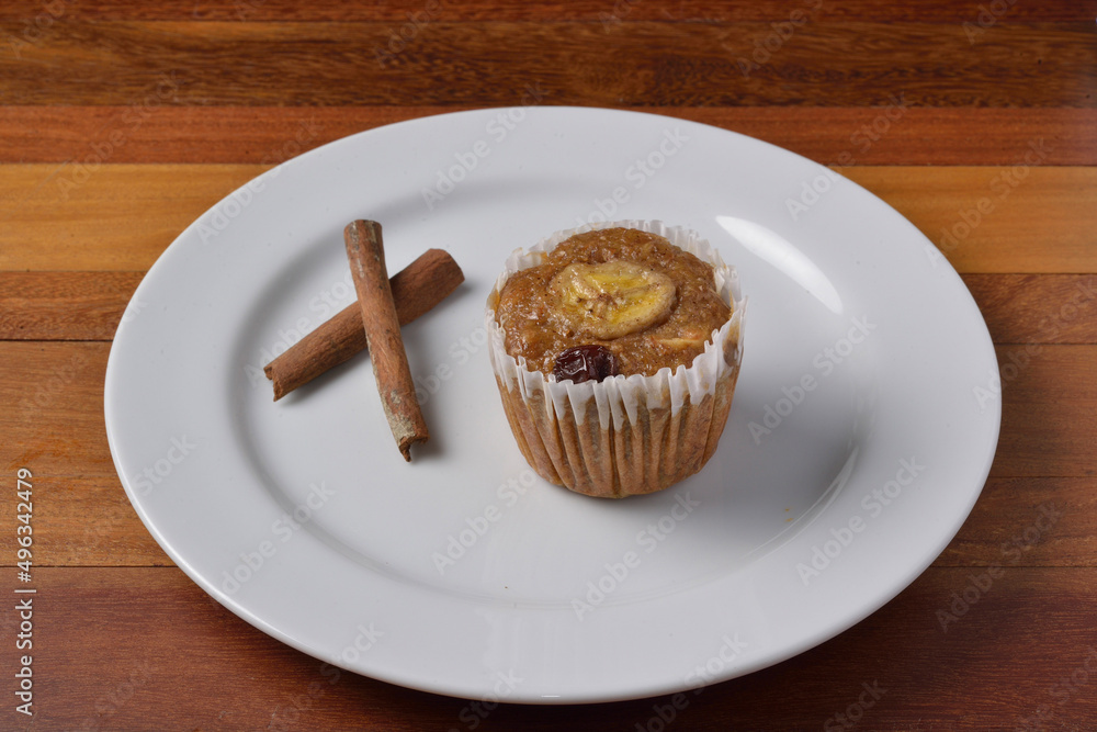 Banana muffin with cinnamon on white plate. Brazilian cuisine. Banana muffin with cinnamon on white plate. Brazilian cuisine.