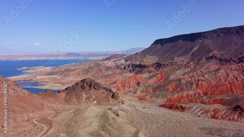 Aerial view overlooking Kingman wash desert and rocky mountains with Lake Mead in the background in sunny, USA - pan, drone shot