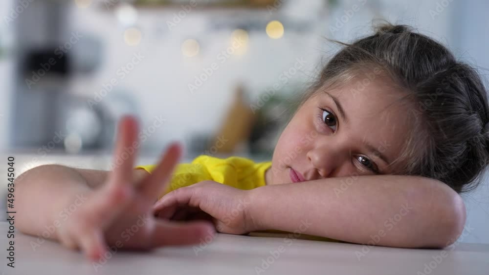 Sad girl at the table in room. Unhappy face of girl. Teenager sits at table. Preschooler child crying while sitting at table in room. Sad lazy kid. Preschool education concept. Man loneliness at home Sad girl at the table in room. Unhappy face of girl. Teenager sits at table. Preschooler child crying while sitting at table in room. Sad lazy kid. Preschool education concept. Man loneliness at home