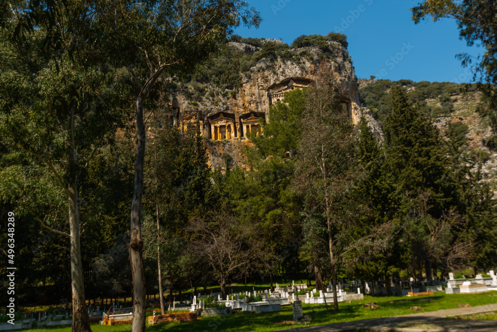 DALYAN, MUGLA, TURKEY: A modern Turkish cemetery and Lycian tombs carved into the rock in the ancient city of Kaunos.
