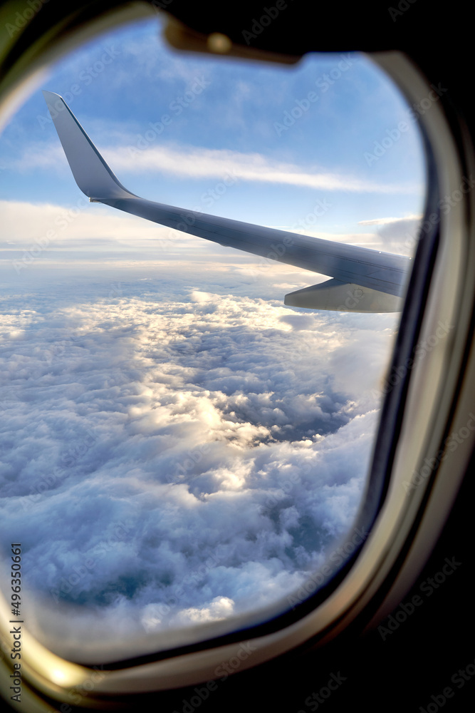 Clouds and sky as seen through window of an airplane during flight