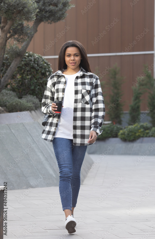 Young african american woman drinking coffee by the street. Young african american woman drinking coffee by the street.