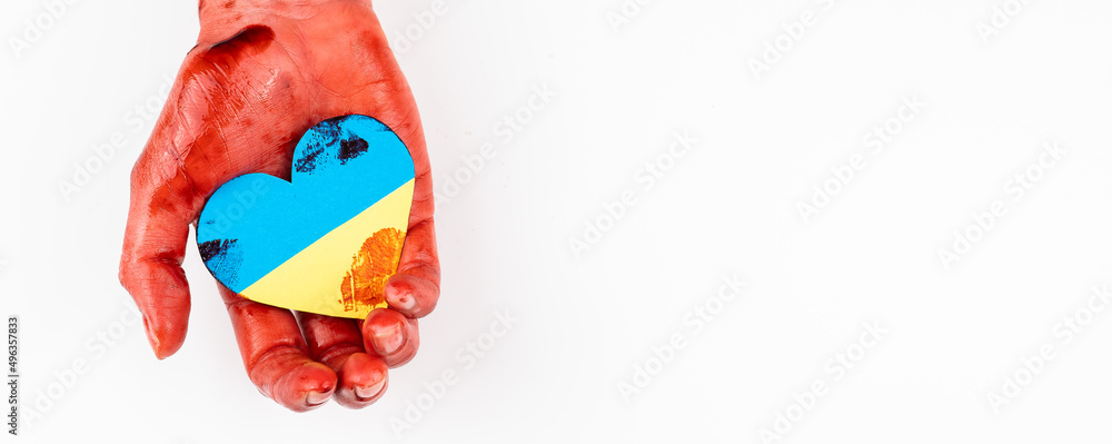 Woman with hands covered in blood holding a heart with the flag of ukraine on a white background. Copy space. 