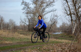 a middle-aged woman rides a gravel bike outside the city. healthy lifestyle. cycling travel. active lifestyle.