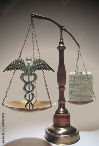 Medical symbol and dollar bills on a balance scale photo