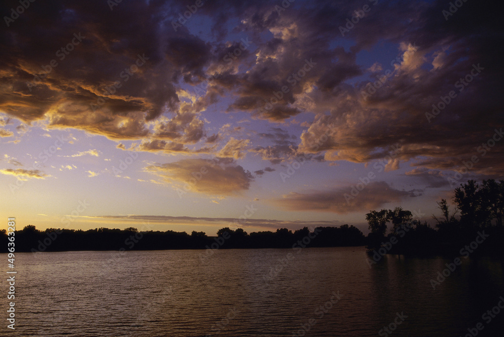 Silhouette of trees across a lake during sunset, Kansas, USA Silhouette of trees across a lake during sunset, Kansas, USA