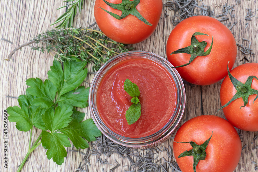 Tomate entero y triturado con hierbas aromáticas, visto desde arriba Tomate entero y triturado con hierbas aromáticas, visto desde arriba