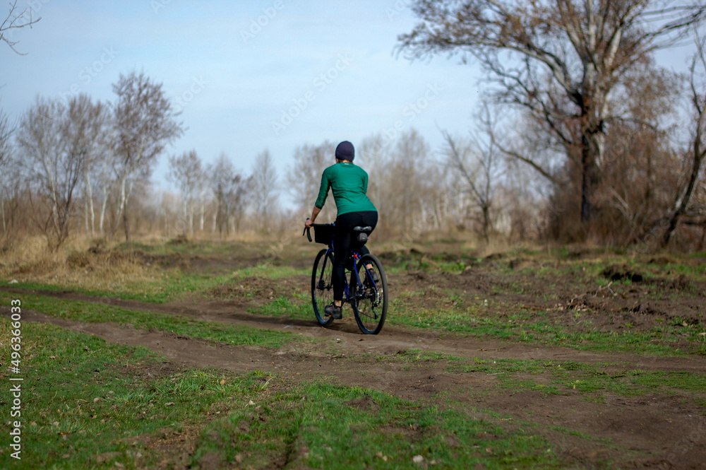 middle-aged woman rides a gravel bike in the forest in sunny weather healthy lifestyle. cycling travel. active lifestyle. middle-aged woman rides a gravel bike in the forest in sunny weather healthy lifestyle. cycling travel. active lifestyle.