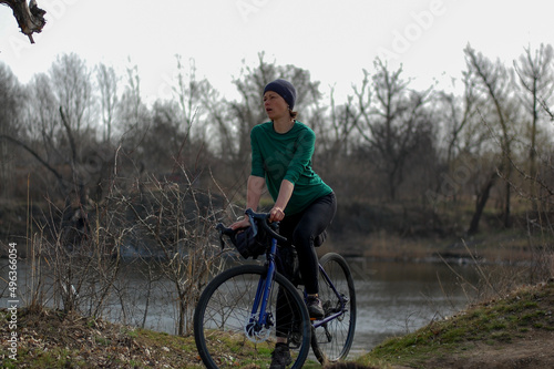 middle-aged woman rides a gravel bike in the forest in sunny weather healthy lifestyle. cycling travel. active lifestyle.