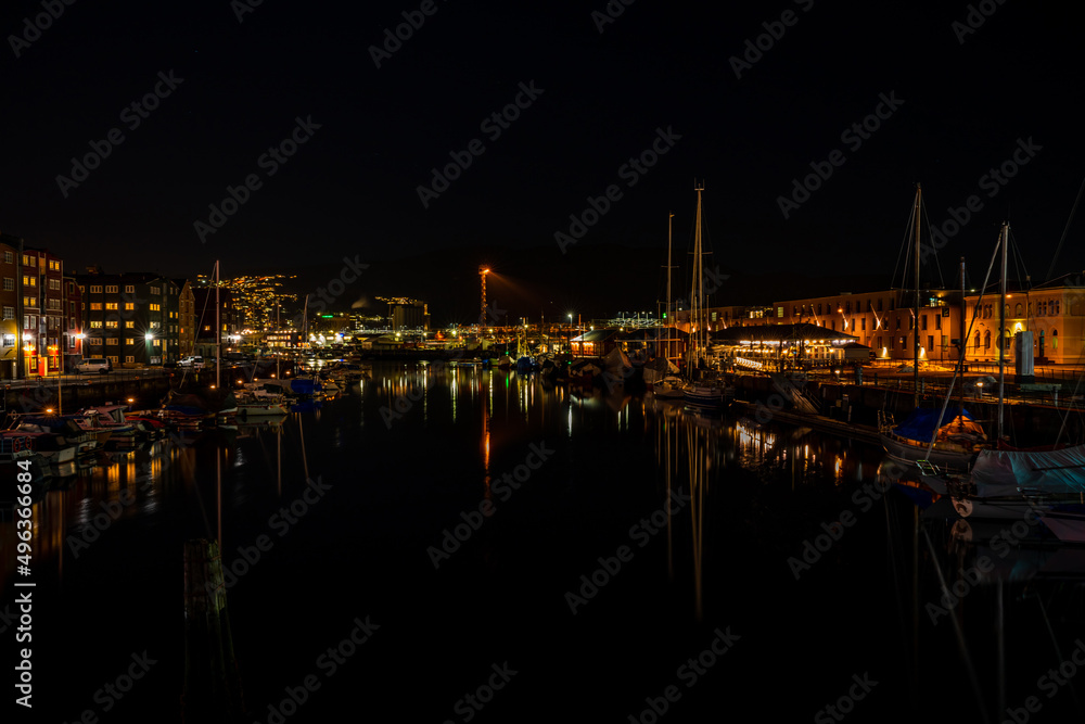 Night view of sailboats moored on the Nidelva river in Trondheim, Norway