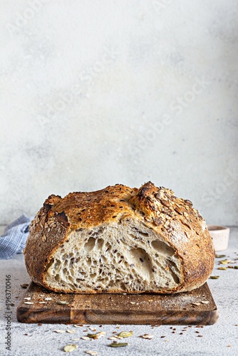 Fresh homemade bread (slice) from whole grain sourdough flour with the addition of bran, seeds (sunflower, pumpkin, flax, sesame) and oatmeal flakes. Healthy food. High quality photo.