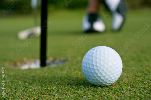 Closeup of golf ball near cup photo