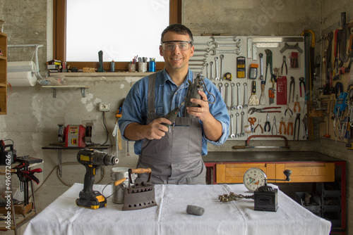 Smiling man in his workshop while restoring antiques.