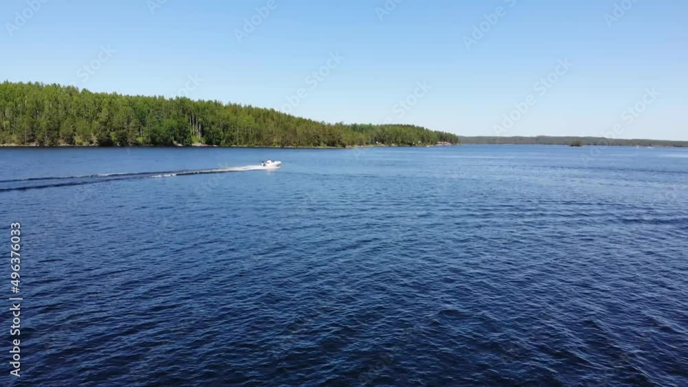 Luftaufnahme von Motorboot fahrend auf Wasser mit Wellen zwischen Inseln mit Bäumen in Schweden auf See bei Sonne per Drohne gefilmt Luftaufnahme von Motorboot fahrend auf Wasser mit Wellen zwischen Inseln mit Bäumen in Schweden auf See bei Sonne per Drohne gefilmt