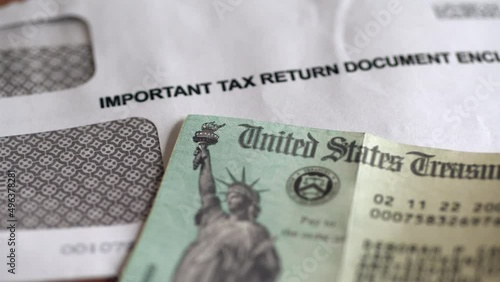 US tax return envelop and US treasury cheque. Slider shot. 