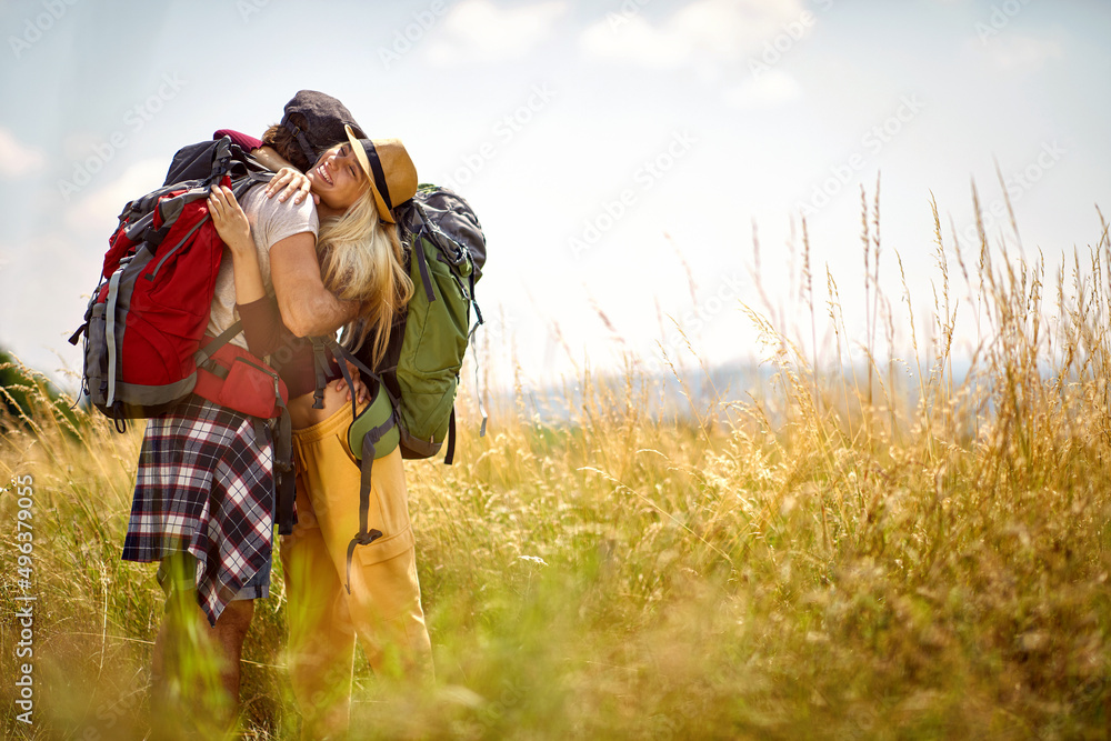 Young couple in a hug while walking in the nature. Hiking, relationship, nature, activity