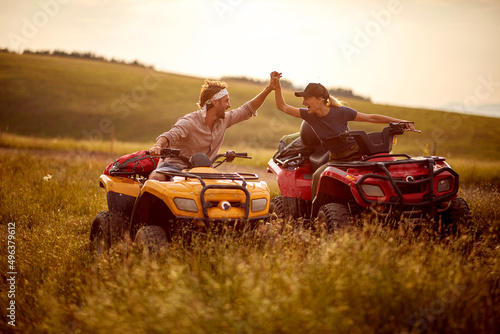 A young couple in love is having fun while riding quads in the nature. Riding, nature, relationship, activity
