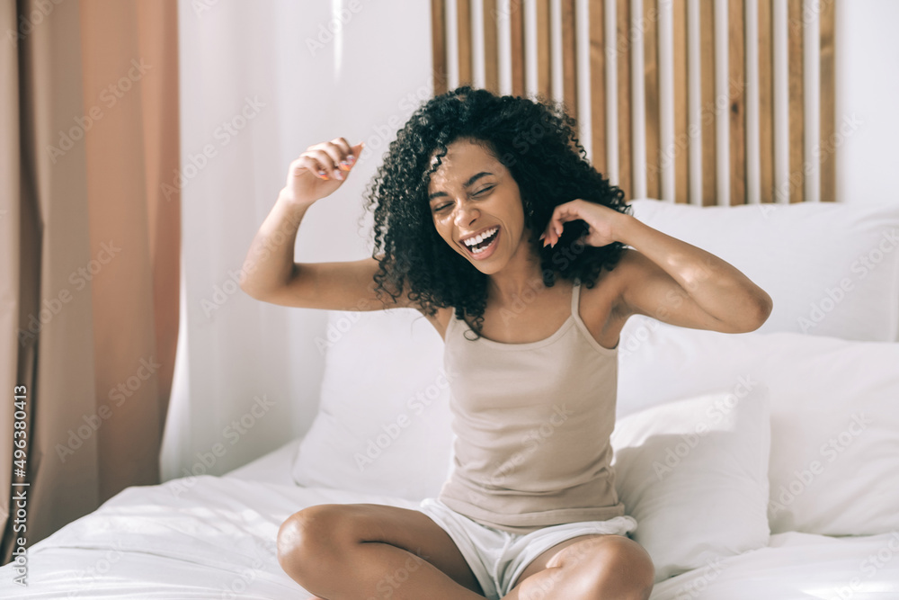 Morning mood and exercise. Young african woman sitting in bed wake up and have fun. Morning mood and exercise. Young african woman sitting in bed wake up and have fun.