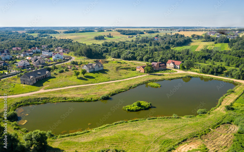 Fototapeta premium Chapsky's estate in the village of Priluki. The manager's house and the brewery building. Black lake. Minsk region. Belarus. View from above. aerial photography