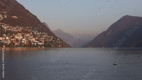 A magnificent Lake Lugano with snow-capped mountains in the background on the Swiss Italian border at sunset, Ticino, Switzerland
