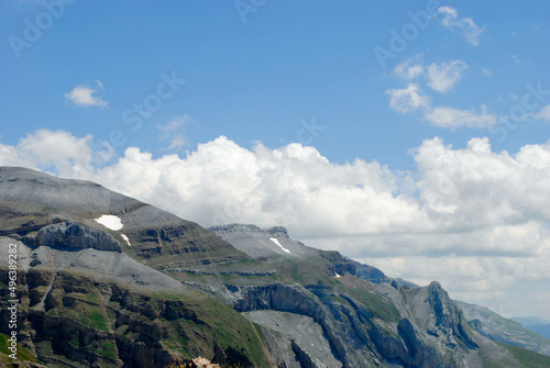 Mountainous landscape of long green mountain ranges with a clear blue sky with few clouds