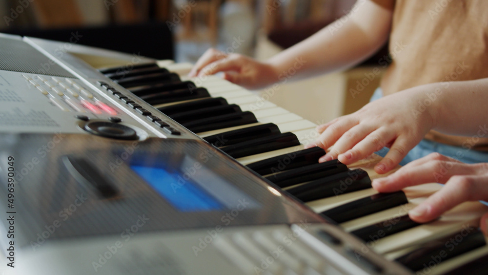 Obraz premium Lesson with a music teacher. Girl learning to play the synthesizer