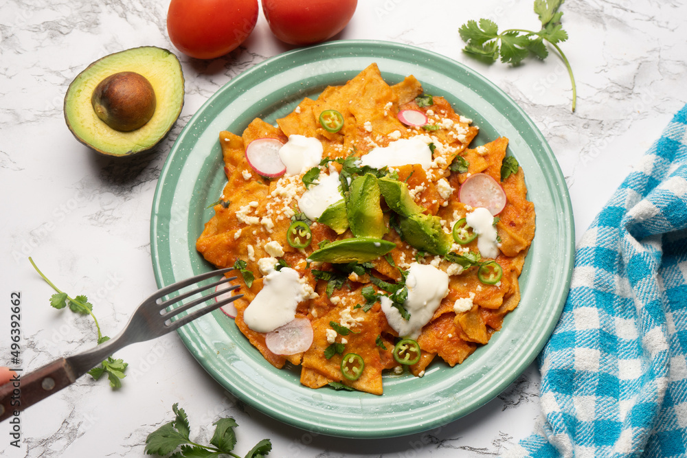 Red chilaquiles with cheese and avocado. Mexican food Red chilaquiles with cheese and avocado. Mexican food
