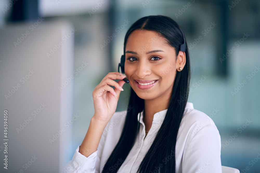 Its all about the client. Shot of a young woman using a headset and computer in a modern office. Its all about the client. Shot of a young woman using a headset and computer in a modern office.