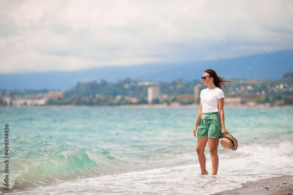 Young happy woman on the beach with mountain view Young happy woman on the beach with mountain view