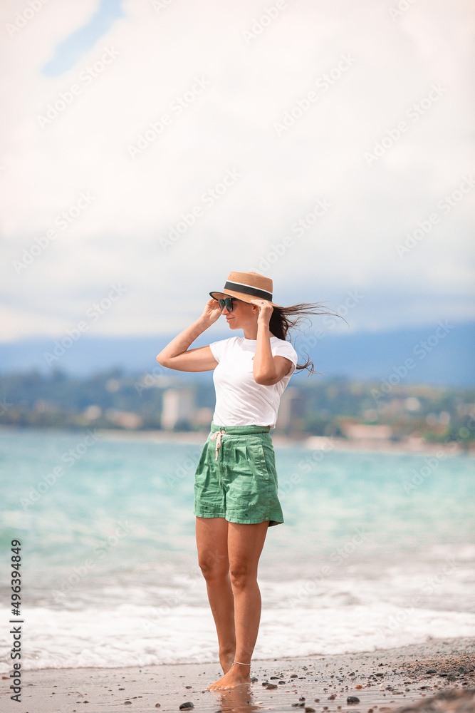 Young happy woman on the beach with mountain view