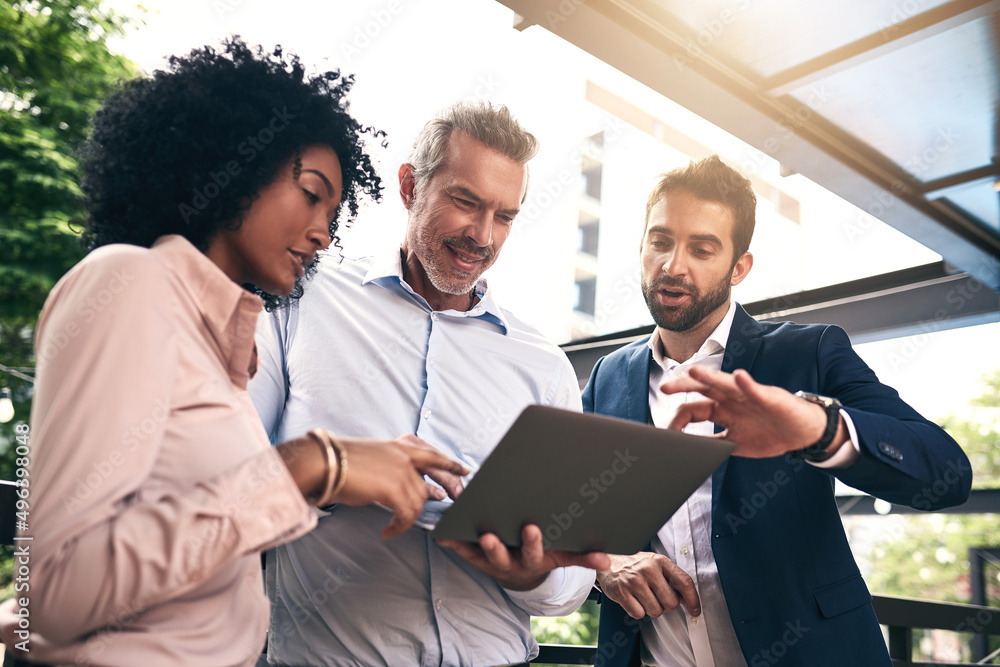 Theyve got some big plans to figure out. Shot of a group of businesspeople working together on a laptop outside. Theyve got some big plans to figure out. Shot of a group of businesspeople working together on a laptop outside.