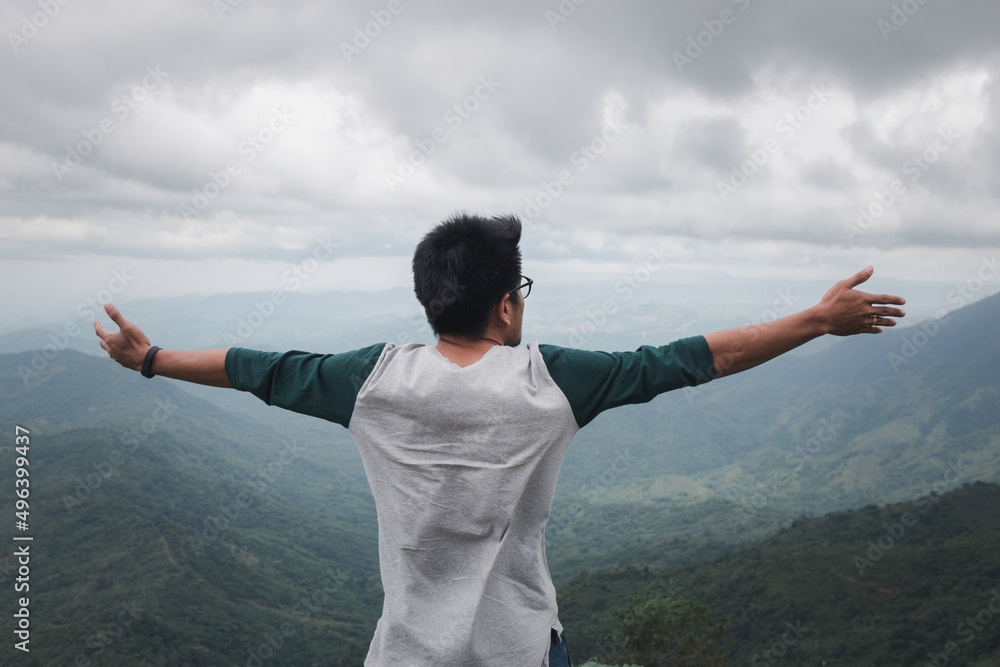 man raises his hands to heaven as a sign of freedom or victory and in the background a fantastic landscape. Concept of: breathing, freedom, journey, life, love.. man raises his hands to heaven as a sign of freedom or victory and in the background a fantastic landscape. Concept of: breathing, freedom, journey, life, love..