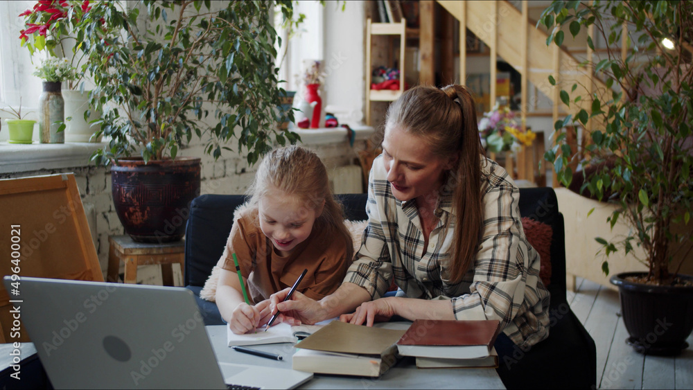 A woman watches her daughter do her homework, prompts her and makes comments A woman watches her daughter do her homework, prompts her and makes comments