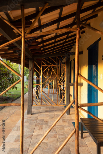 Arquitetura antiga, com madeiras e padrões abstratos em estrutura de madeira cercado de folhas e natureza.