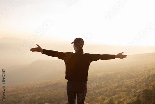 woman raises his hands to heaven as a sign of freedom or victory and in the background a fantastic landscape. Concept of: breathing, freedom, journey, life, love.