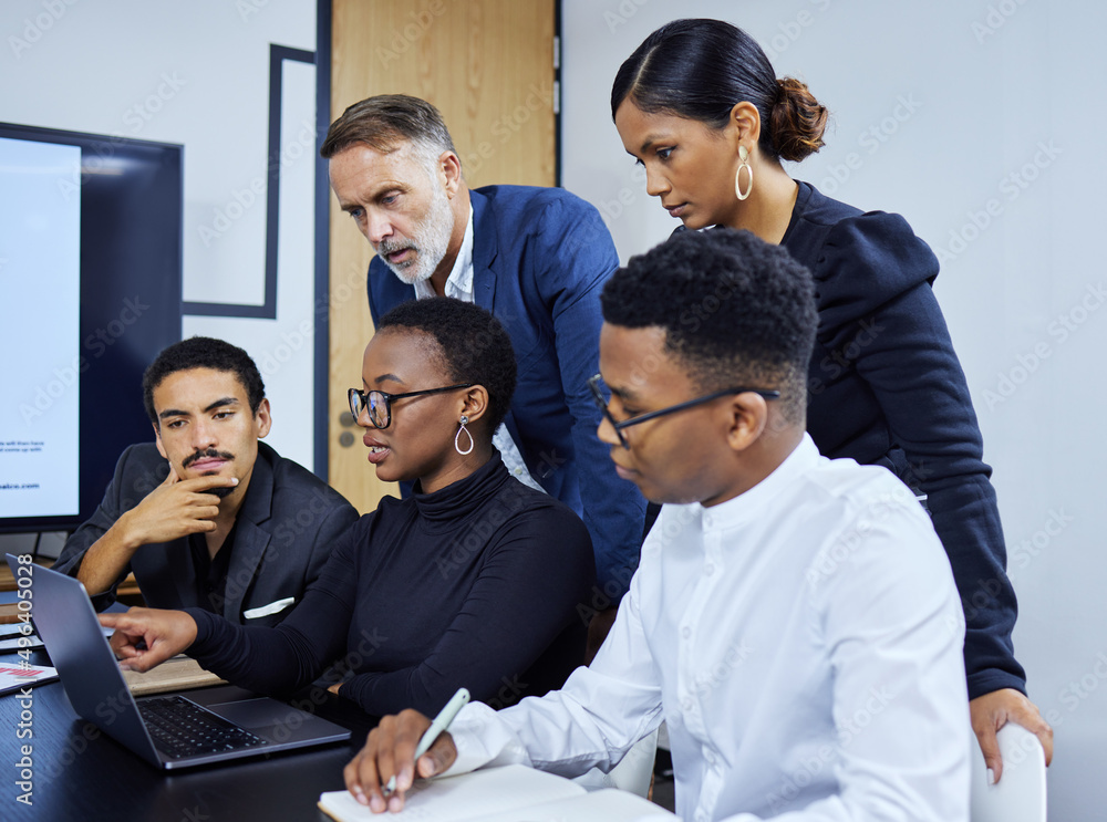 Finalising details for their big plans. Shot of a group of businesspeople working together on a laptop in an office. Finalising details for their big plans. Shot of a group of businesspeople working together on a laptop in an office.