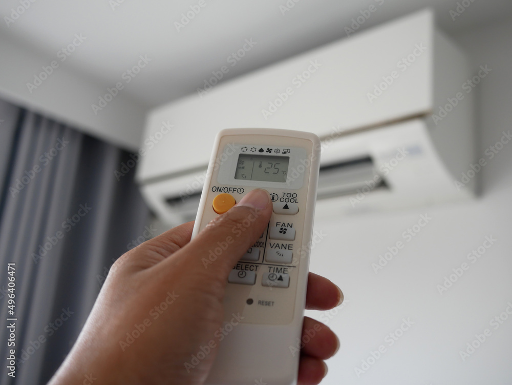 closeup of hand adjust remote control air conditioner. closeup of hand adjust remote control air conditioner.