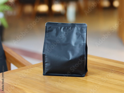 Photo of standing pouch coffee packaging on the cafe table. suitable for mock-up label stickers, coffee variant packaging stickers or etc.