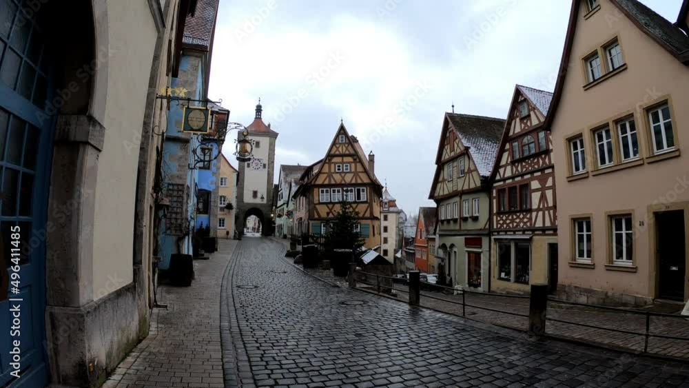 Rothenburg, Germany, December 9, 2021: SLOW - The Plonlein. A yellow timber-frame house at the entrance of the Spital quarter and the two towers of the old city wall, Siebersturm and Kobolzeller Tor. Rothenburg, Germany, December 9, 2021: SLOW - The Plonlein. A yellow timber-frame house at the entrance of the Spital quarter and the two towers of the old city wall, Siebersturm and Kobolzeller Tor.