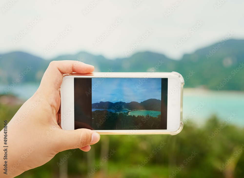 Just a slice of heaven on earth. Cropped shot of an unidentifiable person using a smartphone to photograph a tropical landscape. Just a slice of heaven on earth. Cropped shot of an unidentifiable person using a smartphone to photograph a tropical landscape.