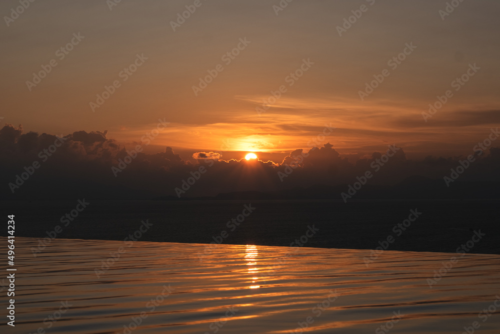 Landscape image of a sunset sky over infinity swimming pool and the sea Landscape image of a sunset sky over infinity swimming pool and the sea