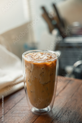 Ice coffee on table with cream being poured into it showing the texture and refreshing look of the drink