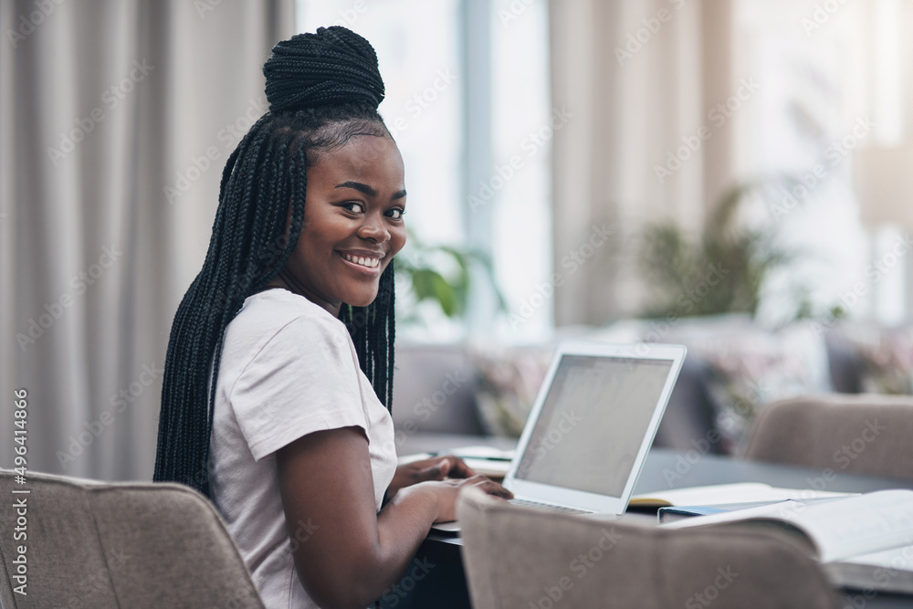 Self quarantine wont stand in the way of my success. Shot of a young woman using a laptop while working from home.