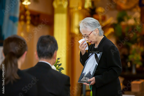 お葬式で挨拶する高齢者女性（喪主の挨拶・泣く） 