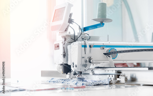 Closeup sewing machine with thread, background white color sun light. Concept Interior of garment factory