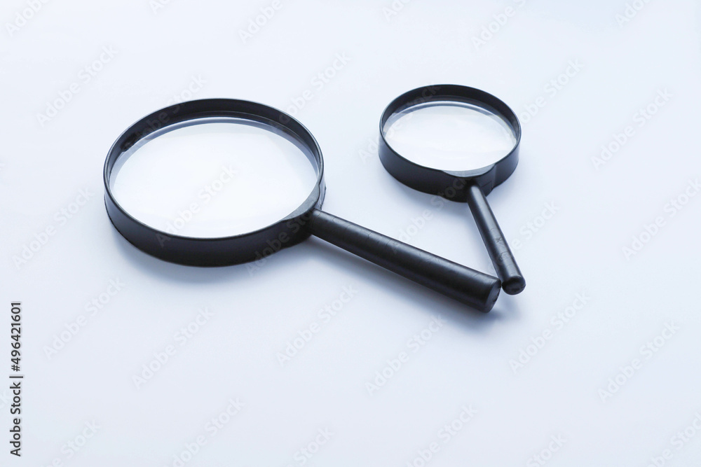 Two magnifying glasses isolated on white background closeup. Two magnifying glasses isolated on white background closeup.