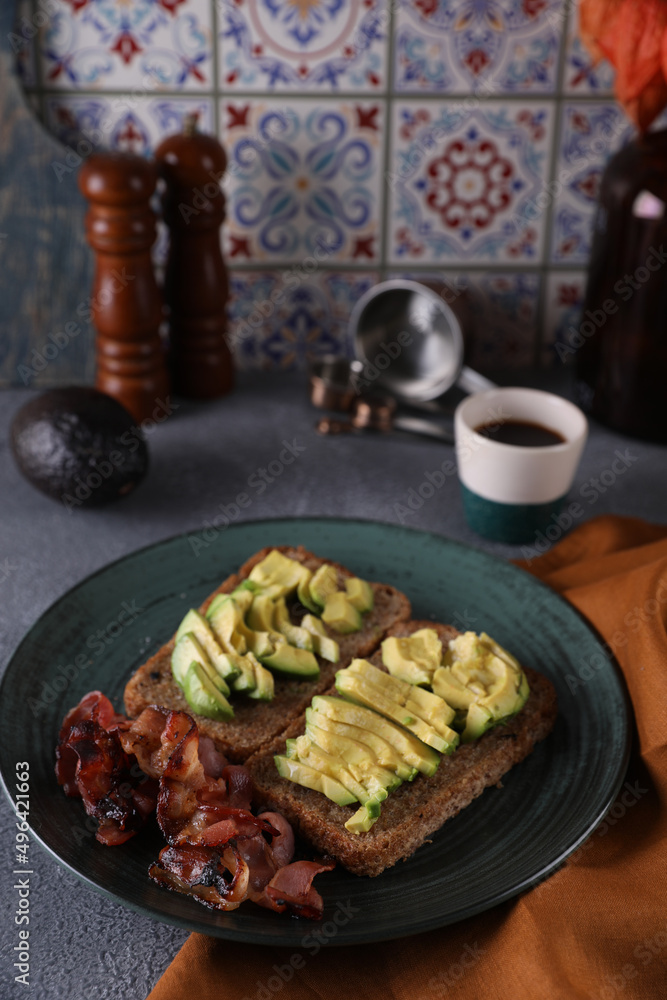 Breakfast with avocado sandwich and fried bacon
