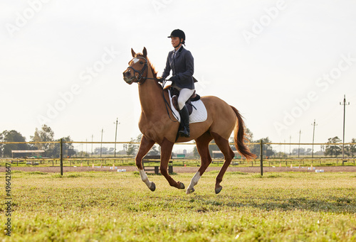 Im free when Im on the saddle. Shot of a young rider jumping over a hurdle on her horse. © Nina L/peopleimages.com