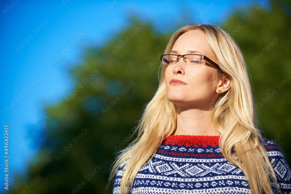 Luxuriating in the winter sun. Shot of an attractive young woman enjoying a day outside.